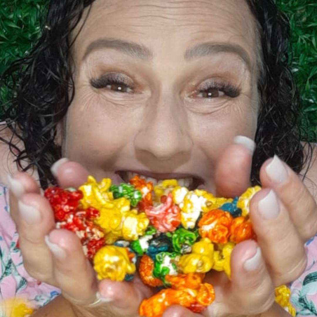 Carla Maria, fundadora da ® Pipo Loucos, segurando pipocas artesanais